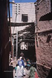 Image du Maroc Professionnelle de  Des enfant jouent sous une Saba au milieu d'une ancienne rue près de la Rahba des Attarines, le Dimanche 21 Décembre 1986. (Photo / Abdeljalil Bounhar)